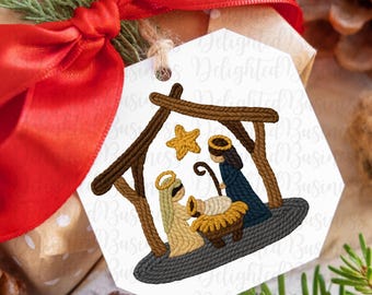 May include: A white hexagonal gift tag featuring a Nativity scene illustration. The scene shows Mary, Joseph, and baby Jesus in a manger, with a star above. The tag is tied to a wrapped gift with a red bow.