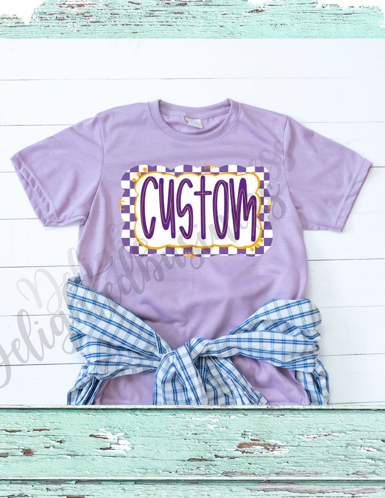 Puede incluir: Una camiseta morada con un borde a cuadros y la palabra "CUSTOM" en un contorno amarillo.