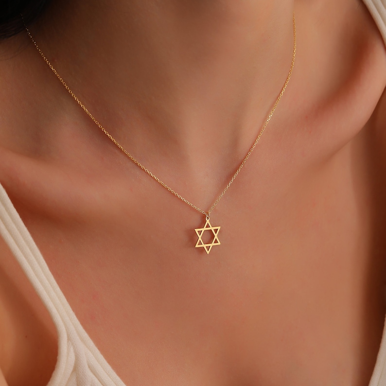 May include: A gold chain necklace with a delicate Star of David pendant.