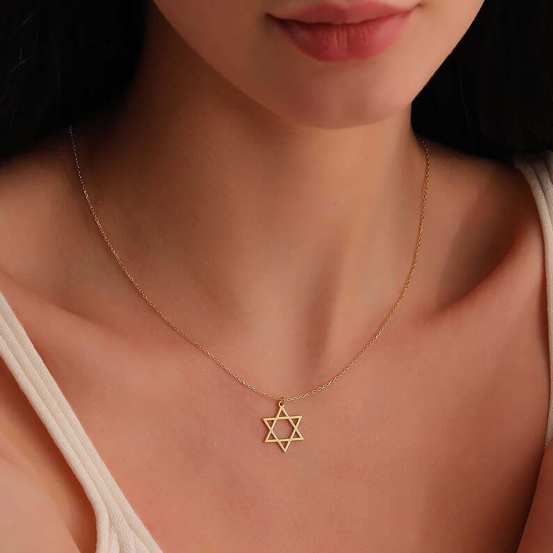 May include: A gold chain necklace with a star of David pendant.