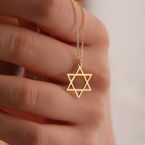 May include: A gold chain necklace with a gold Star of David pendant.