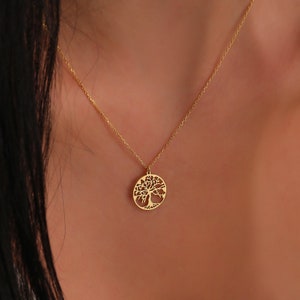 a close up of gold plated tree of life necklace shows its minimalist design better