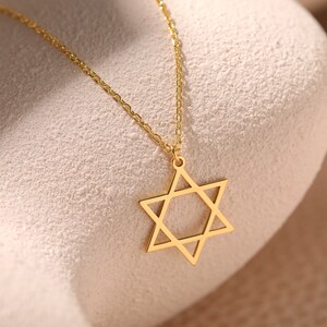 May include: A gold chain necklace with a star of David pendant.