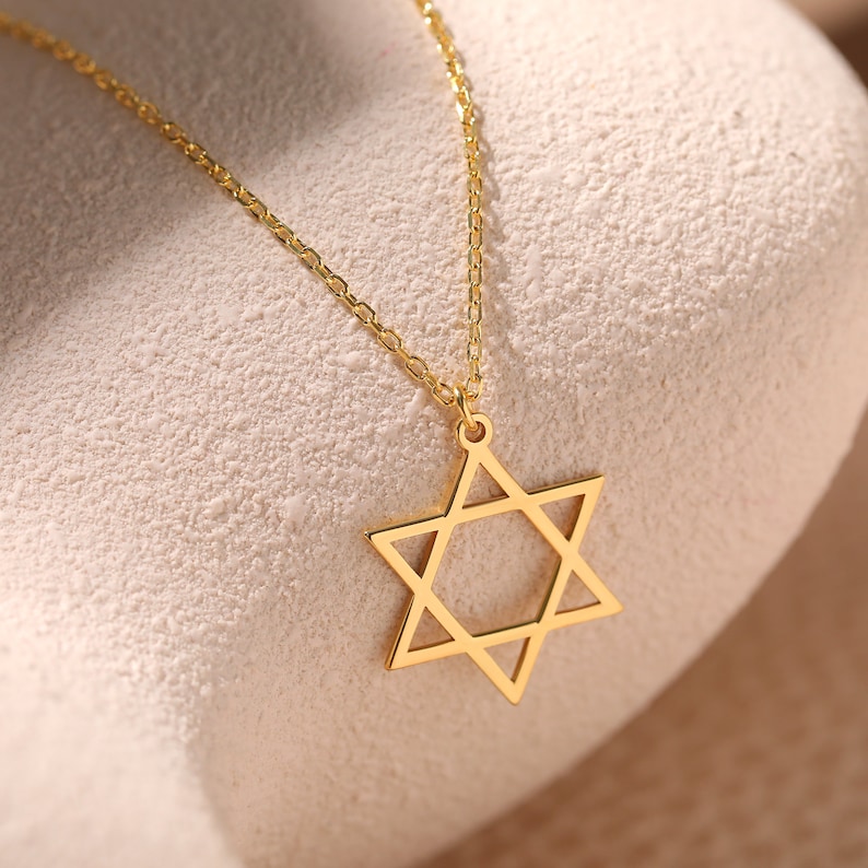 May include: A gold chain necklace with a star of David pendant.