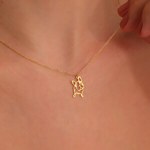 woman adjusting the 14k solid gold chain of frenchie dog pug neclace