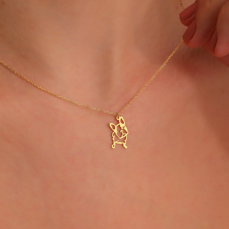 woman adjusting the 14k solid gold chain of frenchie dog pug neclace