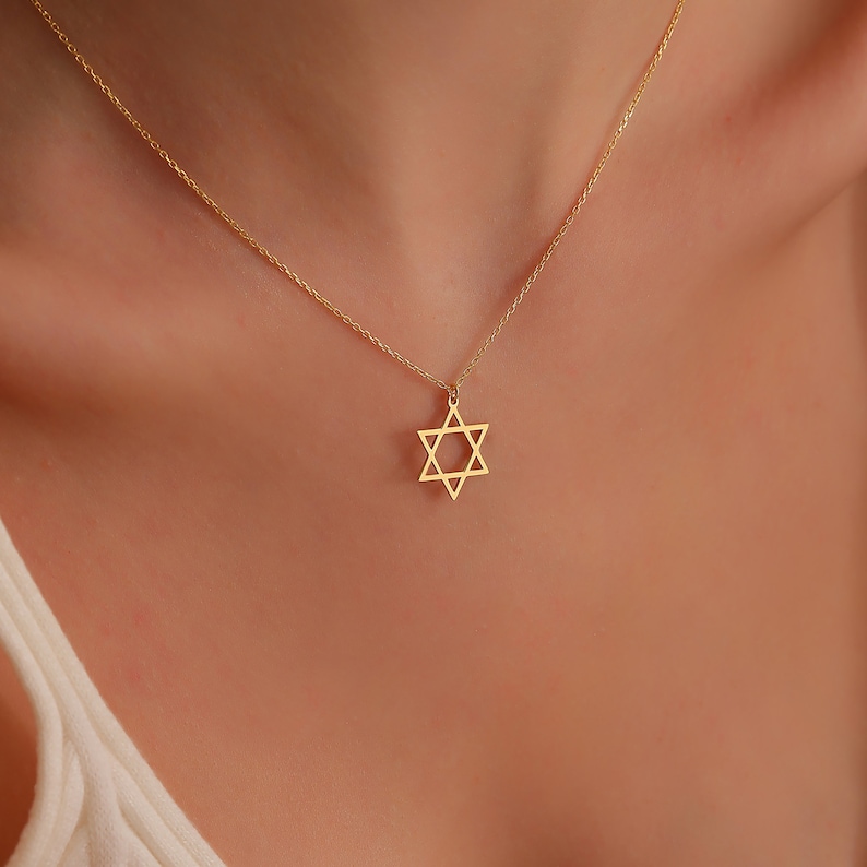May include: A gold chain necklace with a star of David pendant.