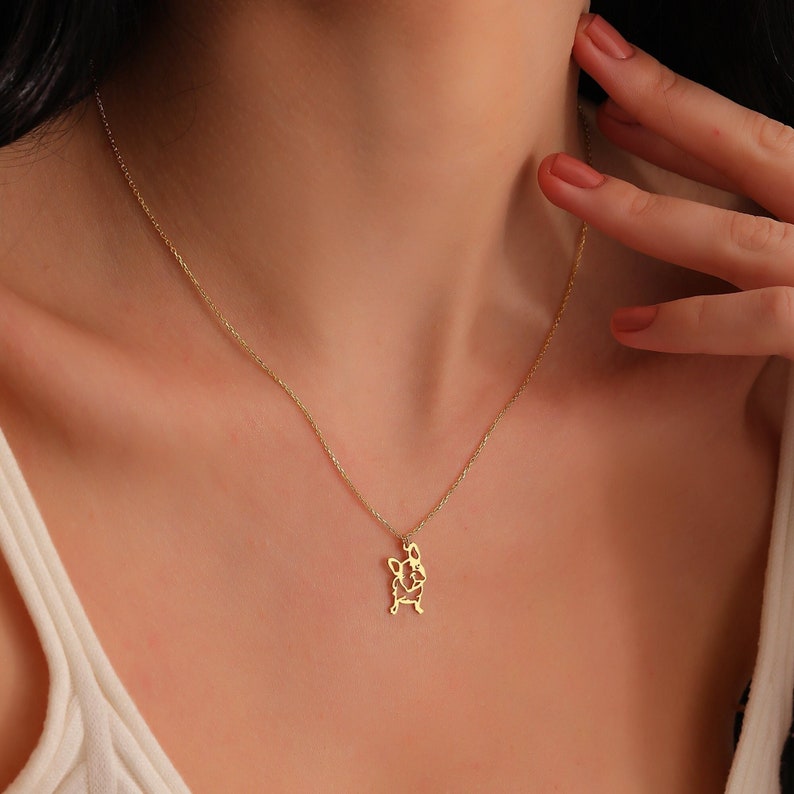 woman wearing 14k solid gold frenchie french bull dog necklace and touching her neck