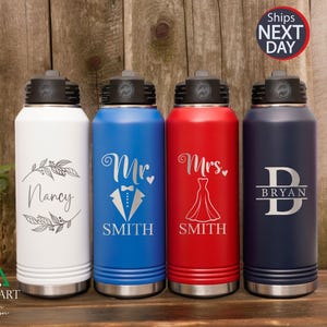 May include: Four stainless steel water bottles with personalized engravings. The bottles are white, blue, red, and navy blue. The white bottle says "Nancy" with a floral design. The blue bottle says "Mr. Smith" with a tuxedo design. The red bottle says "Mrs. Smith" with a wedding dress design. The navy blue bottle says "Bryan" with a letter B design.