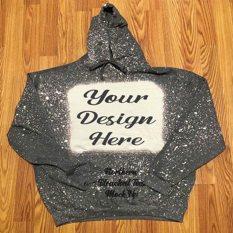 Puede incluir: Sudadera con capucha gris oscuro con un dise&ntilde;o blanqueado blanco y el texto "Your Design Here". La sudadera con capucha tiene un cord&oacute;n y un gran cuadrado blanco en el centro para la colocaci&oacute;n del dise&ntilde;o. Las palabras "Northern Bleached Tees Mock Up" est&aacute;n en la parte inferior.