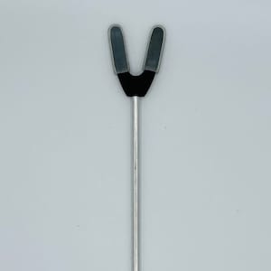 May include: A silver metal tool with a black rubber V-shaped tip. The tool is used for holding open a patient's mouth during a medical procedure.