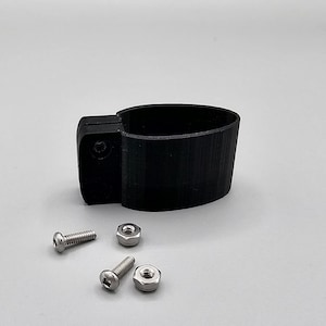 May include: A black plastic clamp with two screws and four nuts. The clamp is designed to hold a round object.