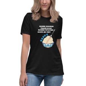 Graphic t-shirt with fun, clever phrase, happiness, mashed potatoes, fork, railroad tracks, blue flowers, floral, black tee