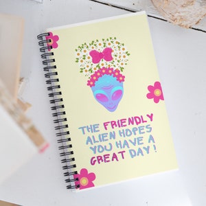 Spiral notebook with sweet, feminine blue alien with flowers in hair, friedly alien, whimsical , inspiring, feel-good design, cute message