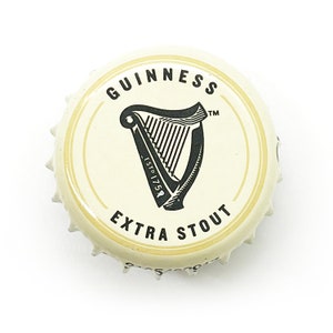 May include: A white bottle cap with a black Guinness logo, featuring a harp and the text "GUINNESS ESTD 1759 EXTRA STOUT TM".