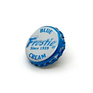 May include: Blue and white bottle cap with the text "Frostie Blue Cream Since 1939" and a registered trademark symbol.