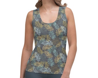 May include: A sleeveless vest top featuring a grey backdrop and a design of fern leaves in gold, blue, and white. The top is worn by a person.