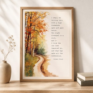 Puede incluir: Una impresión artística enmarcada con una ilustración en acuarela de un sendero forestal otoñal con árboles naranjas y amarillos. El texto dice: I shall be telling this with a sigh Somewhere ages and ages hence: Two roads diverged in a wood, and I- I took the one less traveled by, And that has made all the difference. -Robert Frost.