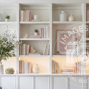 May include: A built-in white bookshelf filled with decorative items. The shelves display stacks of books in neutral tones, vases, small plants, and framed artwork. A large vase with greenery sits on the bottom shelf, creating a serene and stylish interior.