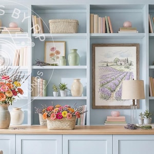 May include: A light blue built-in bookcase filled with books, vases, and decorative items. The shelves display framed artwork, floral arrangements, and woven baskets. A framed print of a lavender field hangs on the center shelf.