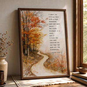 Pode incluir: Uma impressão de arte de parede emoldurada com uma ilustração em aquarela de um caminho sinuoso através de uma floresta de outono com folhagem laranja e amarela. O texto exibe a última estrofe do poema de Robert Frost em fonte de máquina.
