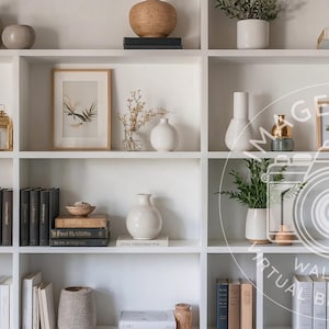 Puede incluir: Una estantería blanca llena de objetos decorativos. Presenta varios jarrones, libros, estampados botánicos enmarcados y pequeñas plantas. La paleta de colores es neutra, con acentos beige, blancos y verdes, creando una estética minimalista.