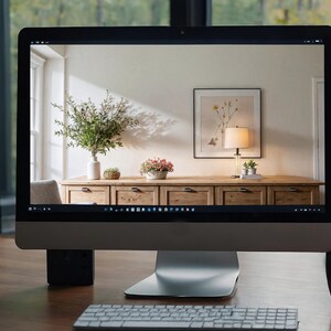 K&ouml;nnte beinhalten: Ein Computermonitor zeigt ein Foto eines Wohnzimmers mit einer Kommode aus Holz, einer Lampe und einem gerahmten Druck. Die Kommode hat sechs Schubladen und ist aus hellem Holz. Die Lampe steht auf einem Tisch neben der Kommode und hat einen wei&szlig;en Schirm. Der gerahmte Druck h&auml;ngt an der Wand &uuml;ber der Kommode und hat einen schwarzen Rahmen. Der Raum ist wei&szlig; gestrichen und hat ein gro&szlig;es Fenster.