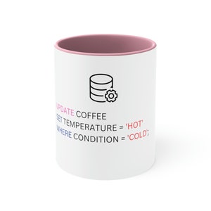 May include: White ceramic coffee mug with a pink rim. The mug features a black and white illustration of a database with a gear icon. The text "UPDATE COFFEE SET TEMPERATURE = 'HOT' WHERE CONDITION = 'COLD';" is printed on the mug.