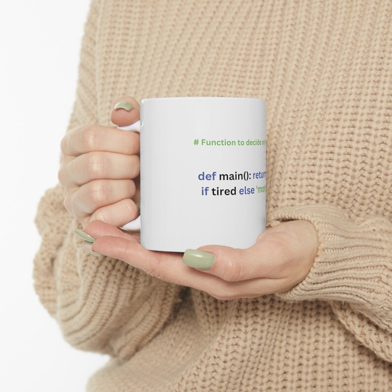May include: White ceramic mug with a green and blue code snippet that reads "# Function to decide on def main(): return if tired else 'more'"