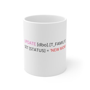 May include: White ceramic mug with black text that reads "UPDATE [dbo].[T_FAMILY] SET [STATUS] = 'NEW MOM'" in pink and red.