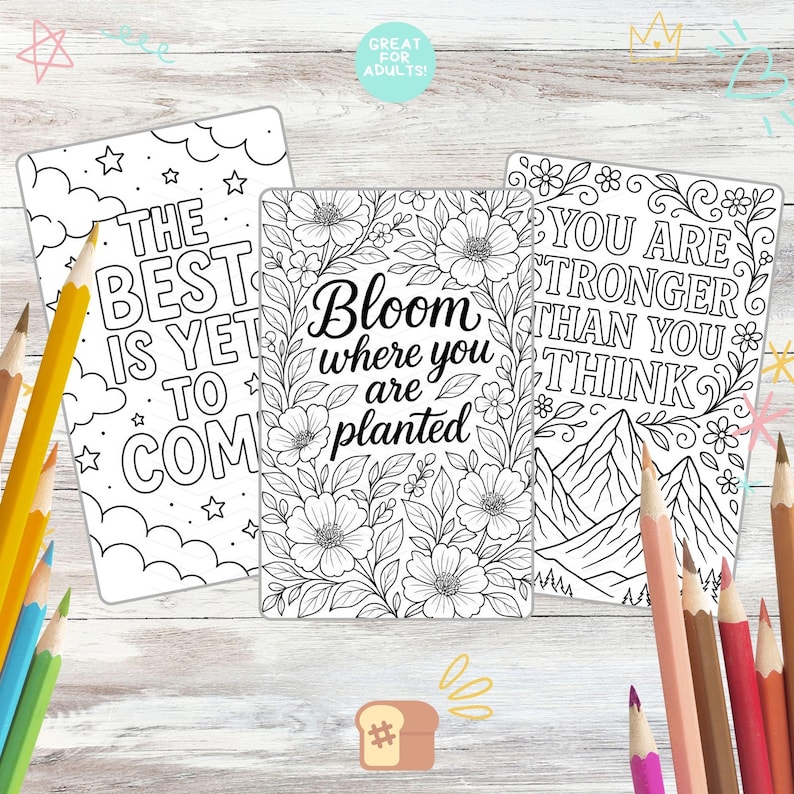 May include: Three black and white coloring pages with inspirational quotes and floral designs. The pages include the phrases "The Best Is Yet To Come", "Bloom where you are planted", and "You are stronger than you think". Colored pencils are scattered around the pages.
