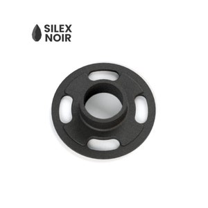 Puede incluir: Un objeto metálico negro circular con una proyección cilíndrica central y cuatro cortes ovalados espaciados. El objeto tiene un acabado mate. El texto "SILEX NOIR" es visible en la esquina superior izquierda.