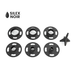 May include: Six black plastic snap fasteners with a star-shaped stud. The fasteners are designed for attaching fabric or other materials.