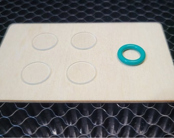May include: A wooden board with five circular cutouts and a turquoise ring on the right side.