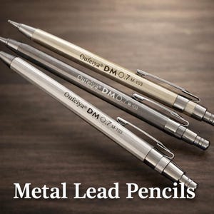 Op de afbeelding: Vier metalen potloden in zilver, grijs en goudtinten zijn diagonaal gerangschikt. Elk potlood heeft een clip en de tekst "Oufeiya DM 0.7 M-103". De woorden "Metal Lead Pencils" staan onderaan.