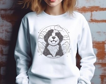 May include: White sweatshirt with a black and white illustration of a dog in a circle. The dog is smiling and has a fluffy coat. The illustration is surrounded by stars and clouds.