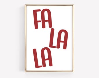May include: A framed print with the words "FA LA LA" in red, bold letters on a white background. The print is in a gold frame and is a festive holiday decoration.
