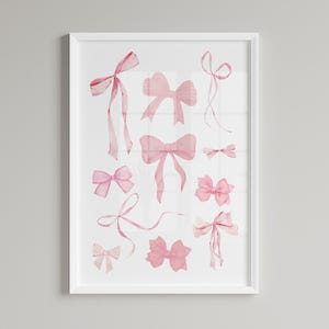 May include: A white framed print featuring a watercolour illustration of pink bows in various sizes and shapes.