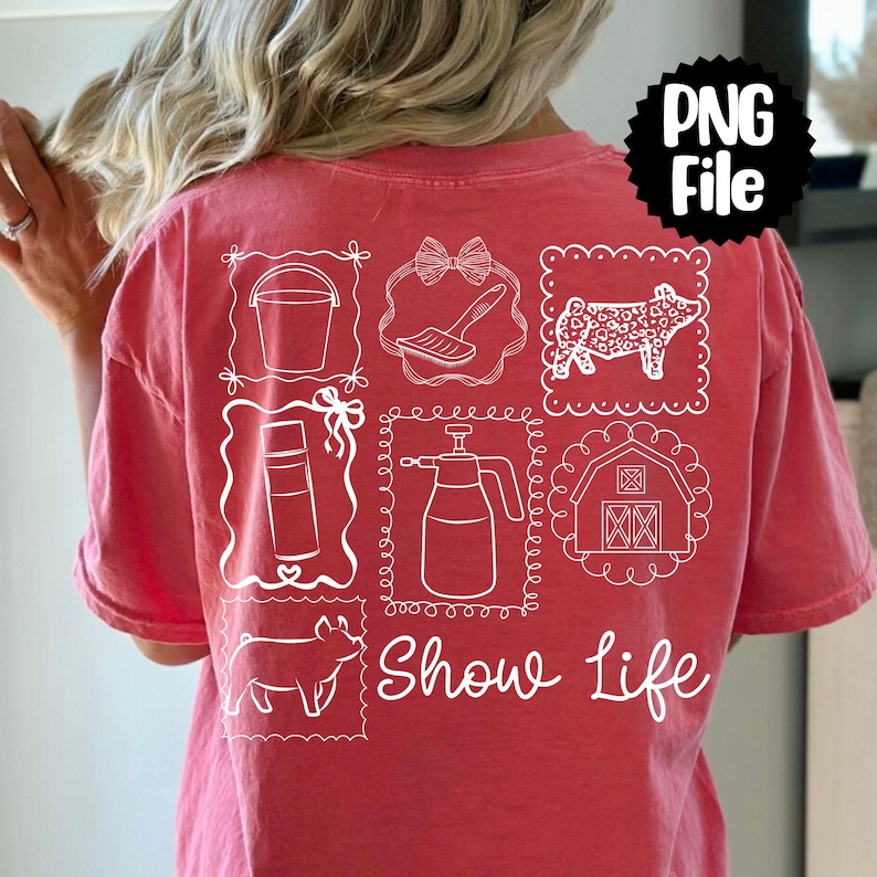 May include: A coral-colored t-shirt with white line drawings of farm-related items, including a bucket, brush, cow, spray bottle, barn, pig, and the words "Show Life". The shirt has a relaxed fit.