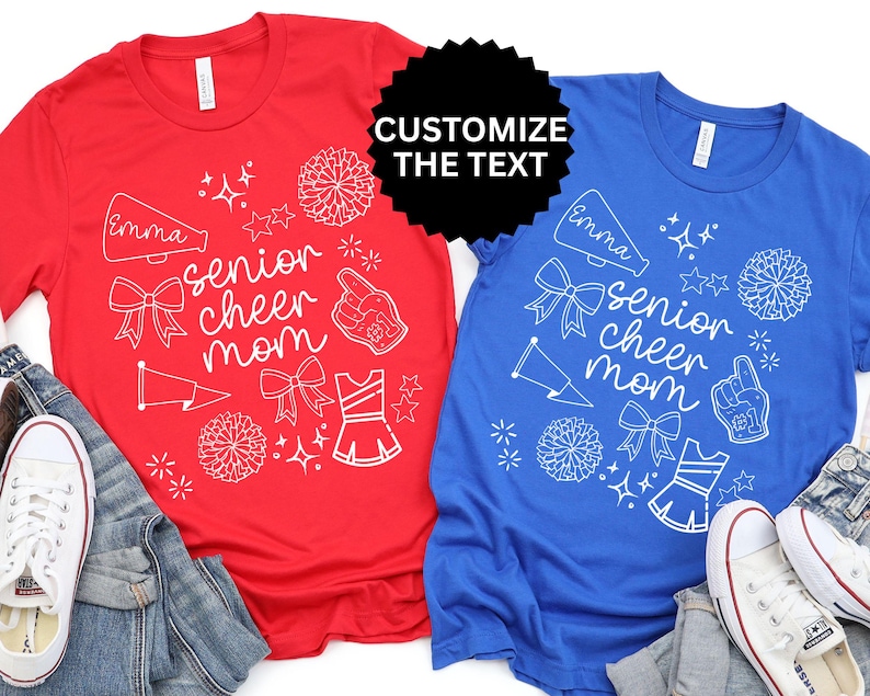 May include: Red and blue t-shirts with white graphic designs. The shirts feature the text "senior cheer mom" with cheerleading-related illustrations. The text "Customize the text" is also visible. White sneakers and denim are in the image.