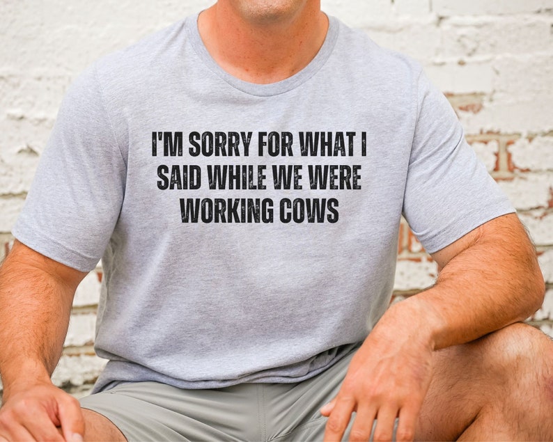 May include: A grey t-shirt with the text "I'm sorry for what I said while we were working cows" printed in black.