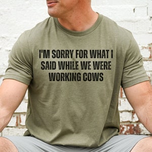 May include: A green t-shirt with the text "I'm sorry for what I said while we were working cows" printed on the front.