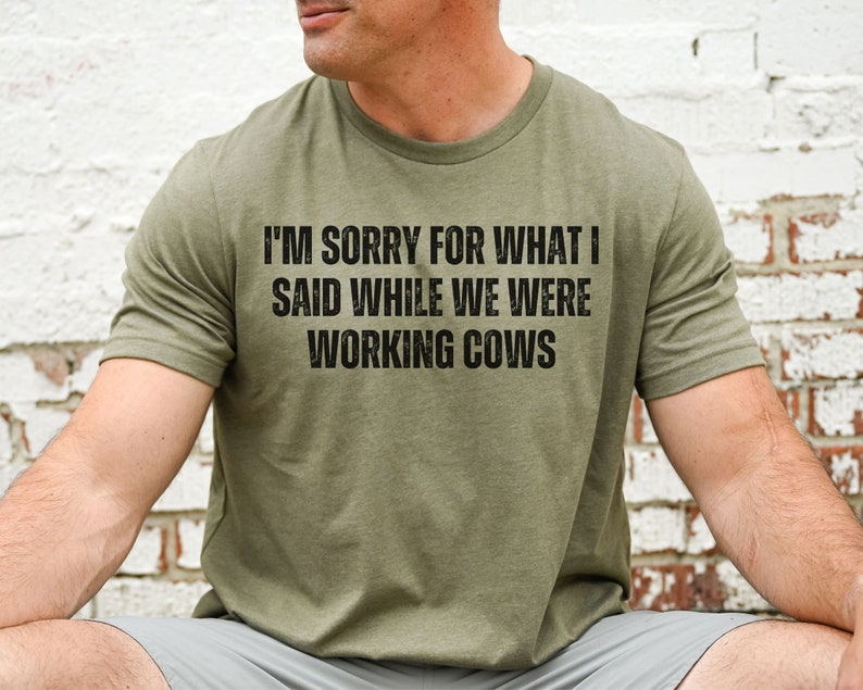 May include: A green t-shirt with the text "I'm sorry for what I said while we were working cows" printed on the front.