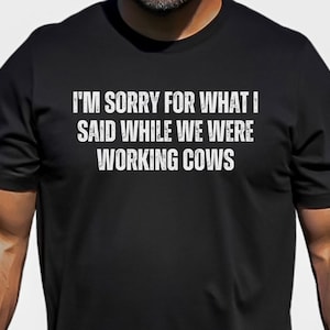May include: Black t-shirt with white text that reads "I'm sorry for what I said while we were working cows."