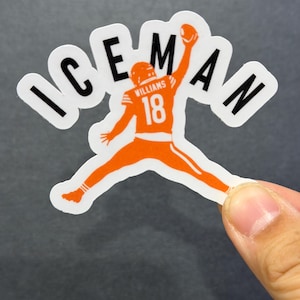 May include: A sticker featuring an orange football player in a leaping pose, holding a football. The word "ICEMAN" arches above the player. The player's jersey has the number 18 and the name "WILLIAMS".