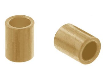 May include: Two beige ceramic spacers, one lying horizontally and the other standing vertically. The spacers are cylindrical in shape with a smooth, matte finish.