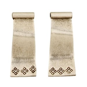 May include: A pair of silver earrings with a textured finish and a geometric design. The earrings are shaped like a rectangle with rounded corners and have a small scroll at the top.