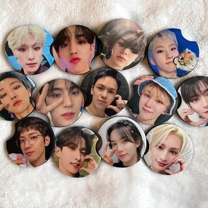 May include: Twelve round drink coasters featuring different images of people. The coasters are black with a white border.