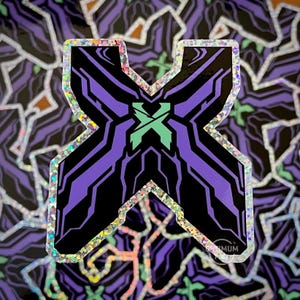 May include: A holographic sticker in the shape of the letter X, featuring a purple and black design with a green X in the center. The sticker has a glittery border and is set against a background of similar stickers.