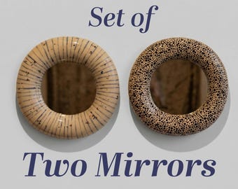 May include: Two decorative, round mirrors. One mirror has a beige and brown striped pattern, and the other has a speckled design. The text "Set of Two Mirrors" is displayed in navy blue.